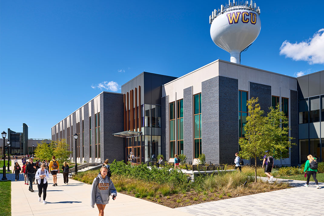 WCU Students walking infront of campus scenary and the WCU water tower