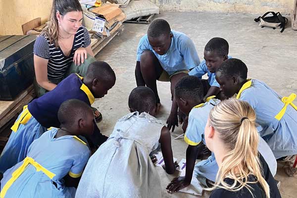 Group of kids & 2 adults in a circle