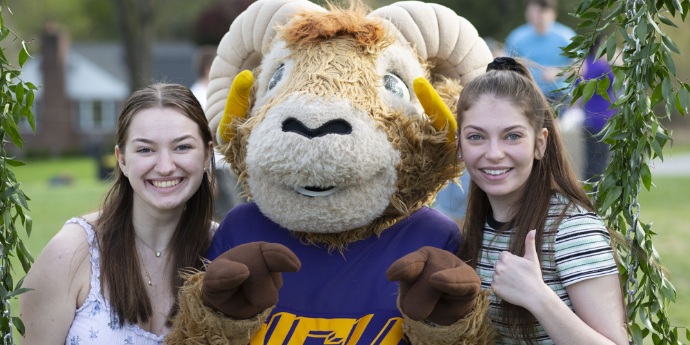 two students giving thumbs up with Rammy 