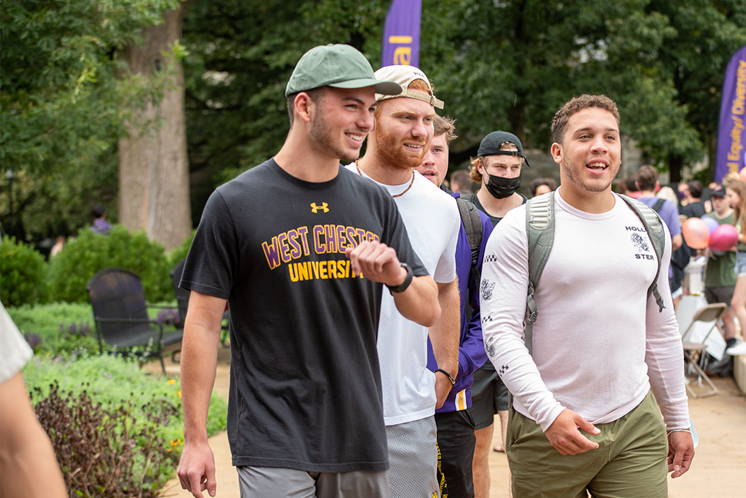 male students outisde walking