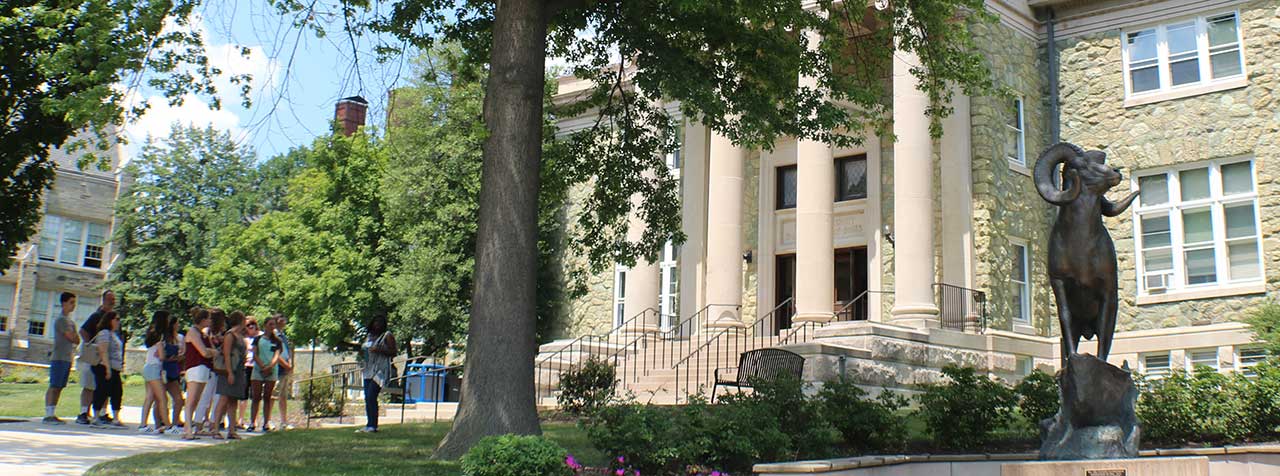 group of students and parents standing in front of Old Library with a tour guide